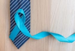 Light blue ribbon and navy blue and white striped tie on wood