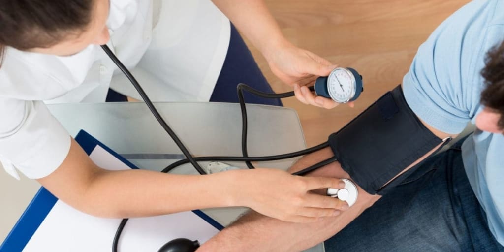 close-up of female doctor checking blood pressure of male patient