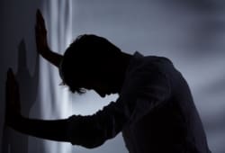 A man standing in the dark with his hands against the wall. If you are depressed or contemplating suicide, there is help. Suicidal thoughts often are caused by a treatable health problem.