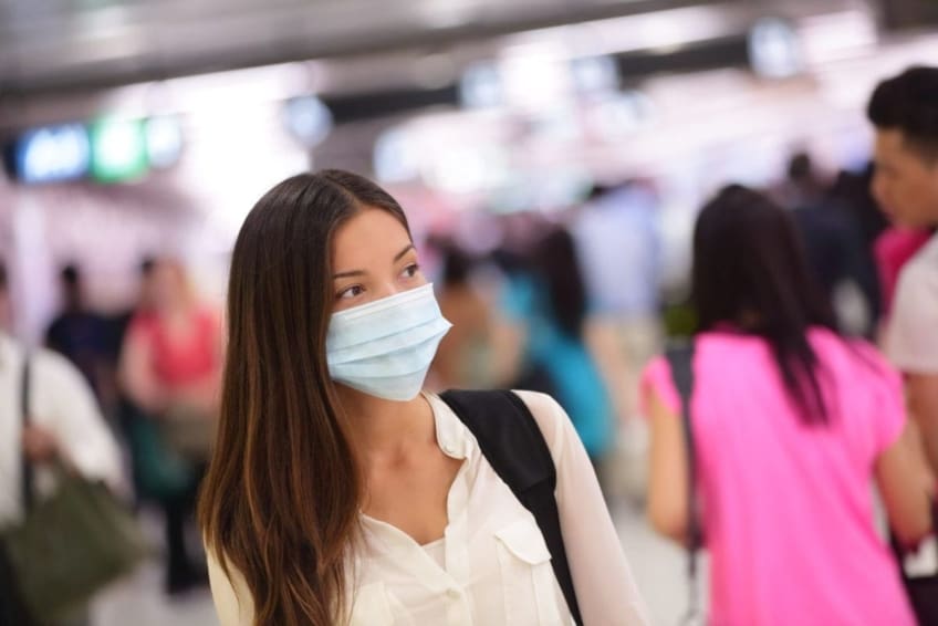 Young woman wearing a mask to protect from getting H1N1 influenza