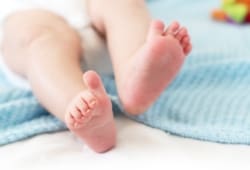 Baby feet on white background with blue blanket