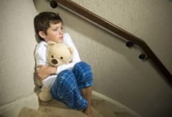 Fearful boy hugging teddy bear