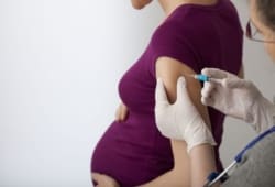 Pregnant woman getting a flu shot in the arm