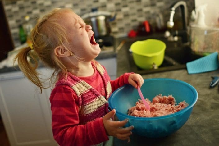 Little girl crying over a bowl