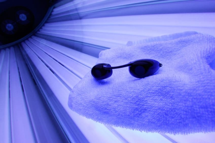 Tanning bed with glasses and towel