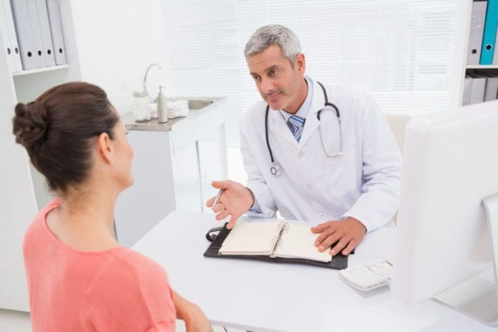 Doctor talking to patient in office