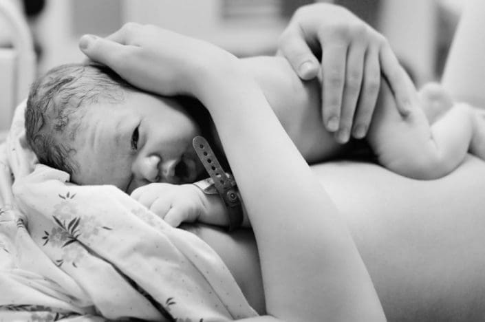 Newborn baby lying on mother’s bare chest
