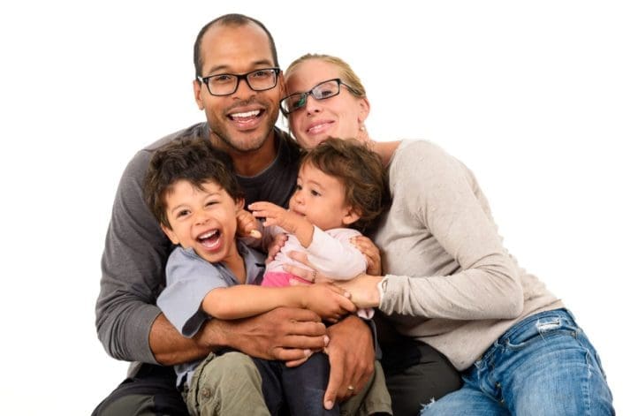 Mother and father holding two giggling children