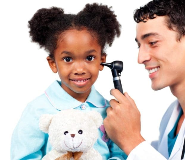 Little girl smiling as doctor examines her ear