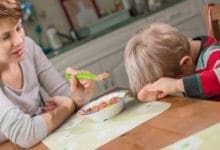 Child with head down on table, refusing to eat