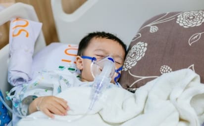 A toddler wears an oxygen mask. RSV (respiratory syncytial virus) is a common virus that makes it hard to breathe. RSV is common in children under 2, but anyone can get it.