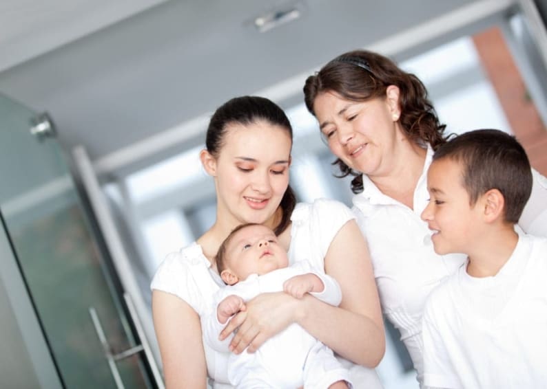 Family holding newborn, leaving the hospital