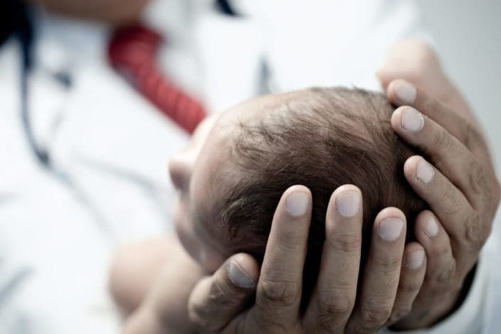 Doctor holding a newborn baby’s head