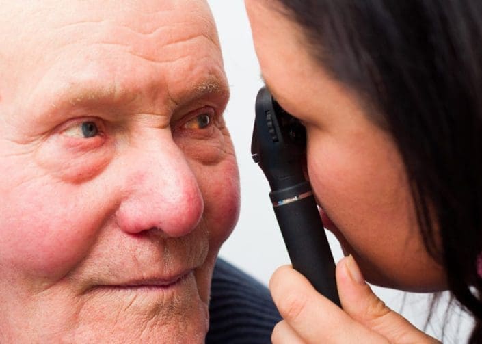 Doctor examining senior man's eye