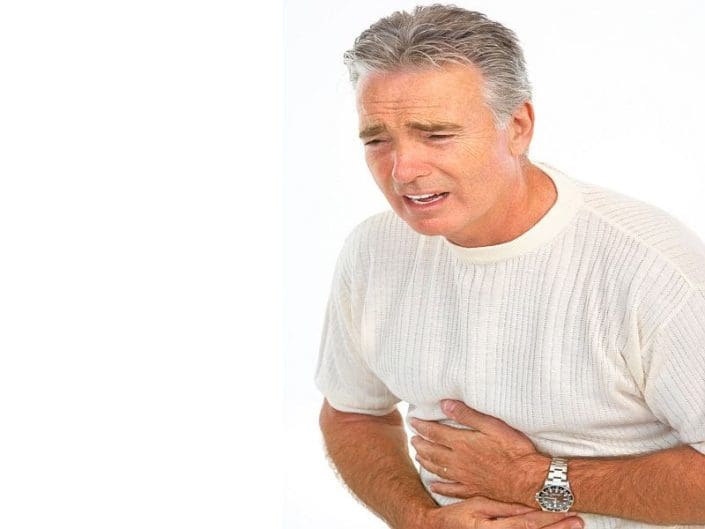 A man suffering from an ulcer clutches his abdomen in pain. An ulcer is a sore on the lining of your stomach or small intestine. Ulcer symptoms include stomach pain, bloating and feeling full fast.