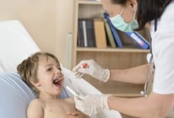 A young boy has his throat swabbed by a doctor. Rheumatic fever is a rare inflammatory disease. It’s tied to the bacteria that causes strep throat and scarlet fever.