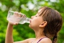 sweaty girl drinking water from a bottle outside