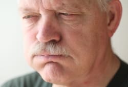 A senior man experiences bloating and reflux from indigestion.