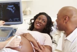 Pregnant woman and partner having ultrasound scan