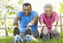 older couple stretching before exercise in a park