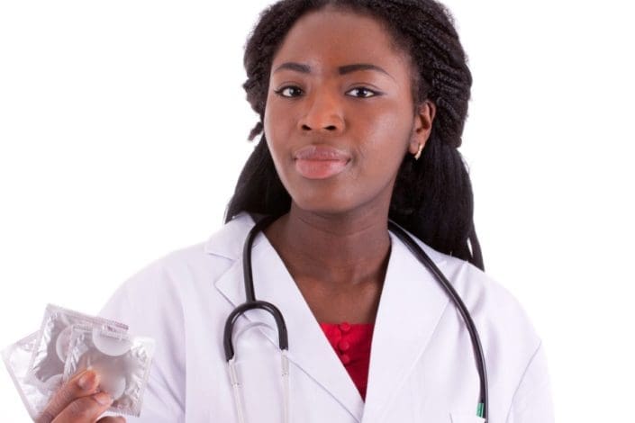 young female doctor holding a condom