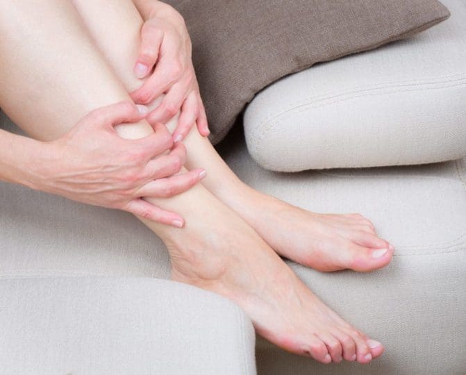 woman holding shins in pain
