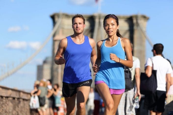 Couple running on Brooklyn Bridge in New York City