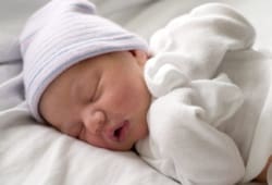 newborn baby lying in bed