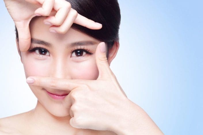 Woman making a frame with hands around her eyes