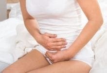 woman holding stomach in pain
