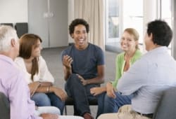 a support group sits in a circle and laughs