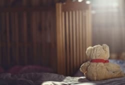 teddy bear sitting in an empty nursery