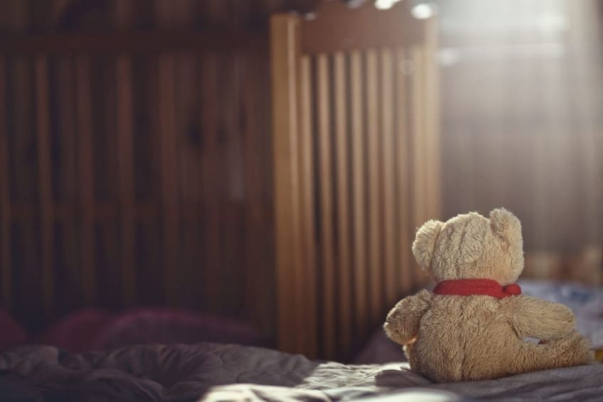 teddy bear sitting in an empty nursery