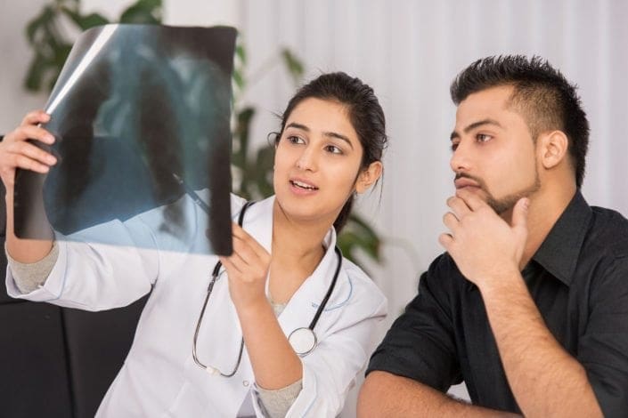 female doctor looks at X-ray with a male patient