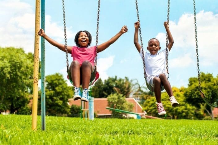 happy children play on a swing set