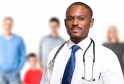 family doctor stands in front of blurred family in background