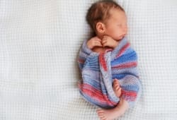 newborn baby wrapped up in a blanket sleeping