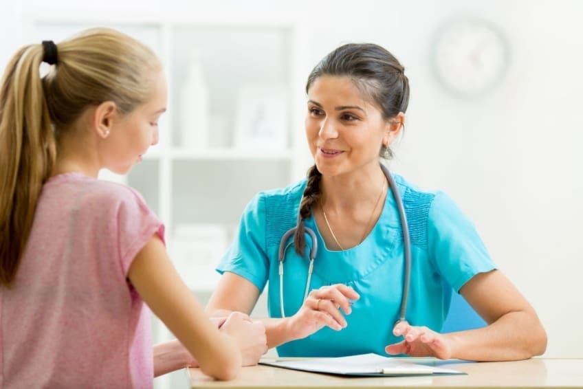 teenager talking to a doctor in the doctor’s office