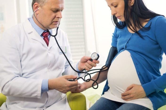 Doctor measures the blood pressure of a pregnant woman