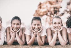 Five women laying horizontally in a line on the ground holding their heads in the palms of their hands. For optimal preventive care, women should have an annual visit that includes a physical and discussion of screenings and emotional well being.