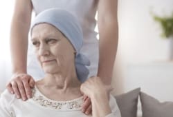 A crying elderly woman with cancer is comforted by a caretaker. Pancreatic cancer is an abnormal growth of cells in the pancreas. It is difficult to detect early, making treatment tough at later stages.