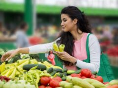 pretty young woman buying vegetables on the market