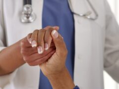Close-up doctor holding female patient’s hand