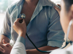 Asian doctor is using a stethoscope listen to the heartbeat of the elderly patient.