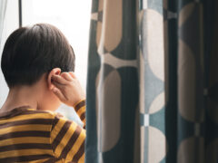 Little Asian boy stand by window, cry and cover ears feeling fear, insecure, anxiety and stress. Domestic Violence, Autism disorder spectrum awareness and Childhood mental disorders problem concept.
