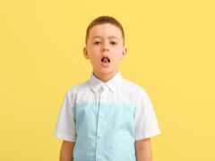 Little boy training pronounce letters on color background