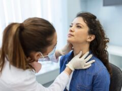 Endocrinologist examining throat of young woman in clinic. Women with thyroid gland test . Endocrinology, hormones and treatment. Inflammation of the sore throat