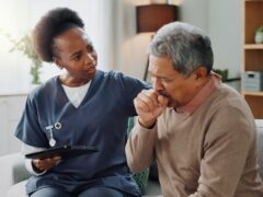 Home, nurse and senior man with cough or tablet in consultation with support or help. Sick, patient or elderly caregiver with person in hospice with lung cancer, tuberculosis or breathing with asma