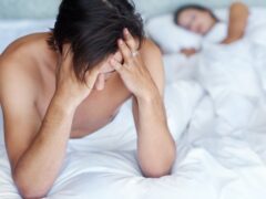 Man, depressed and bed with partner in bedroom for stress, headache and toxic relationship at home. Mental health, sad person and woman asleep for disagreement, anger and erectile dysfunction