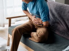 Woman has stomach ache and press hands to stomach due to menstrual cramps period cramps splenomegaly food poisoning excess gas or acid